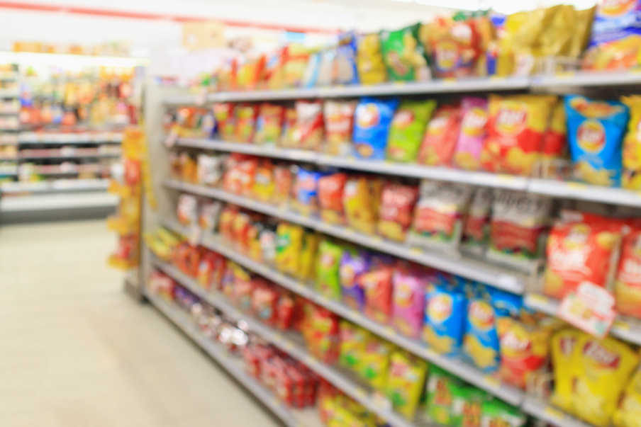 Supermarket convenience store shelves with Potato chips snack blur abstract background